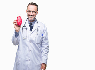 Middle age senior hoary cardiologist doctor man holding heart over isolated background with a happy...