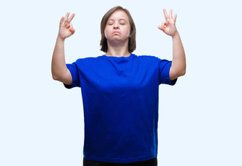 Young adult woman with down syndrome over isolated background relax and smiling with eyes closed doing meditation gesture with fingers. Yoga concept.