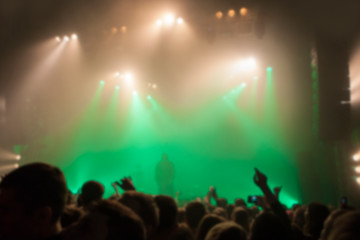 Fototapeta na wymiar Musical concert. People in the concert hall at the disco . Singer in front of the audience. Fans at the concert. Blurred image / blurred photo.