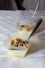 Close Up of Two Glasses of Panna Cotta and Chopped Nuts on Blur Background