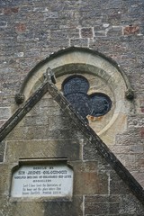 Luss, Scotland, UK: Detail of the Luss Parish Church (1875) including the dedication plaque and stained-glass window.
