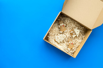 Order goods online concept. Cardboard box with gingerbread cookies on blue background top view space for text