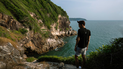 Man traveler see view on the mountain clift at sea
