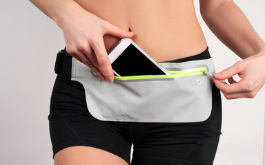 Fitness woman wear waist bag with smartphone inside