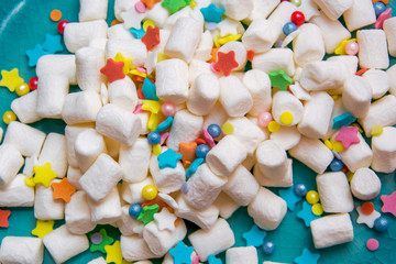 marshmallow and colorful festive sprinkling on a blue plate. macro.