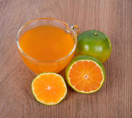 Orange and orange juice on wooden floor