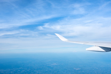 Aerial view of cloud and sky and land with airplane wing from airplane window ,Travel and transportation concept.