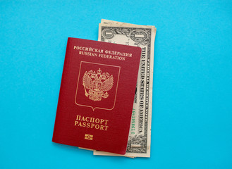 Russian passport with American dollars on the yellow background flat lay