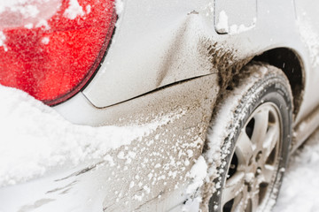 Scratched wing and rear bumper of automobile  after winter collision in city, car crash accident....