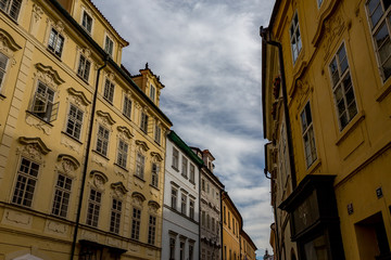 Obraz premium PRAGUE, CZECH REPUBLIC - AUGUST 27, 2015: Light falls in a scenery way upon the beautiful windows of old architecture street in Prague in overcast summer day in the old center of the Czech capital