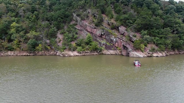 Razor sharp cliffs on the shores of Raystown lake in Pennsylvania offers many outdoor recreational activities, motorboating and watersports. Fast moving dolly shot revealing a motor boat
