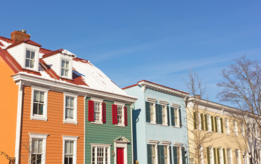 Historic residential houses in Georgetown neighborhood during winter, Washington DC, USA. Colorful houses shine under a blue sky after recent snowstorm.