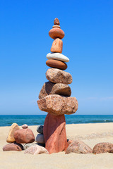 Fototapeta na wymiar Rock zen pyramid of colorful pebbles on the background of the sea. Concept of balance, harmony and meditation.