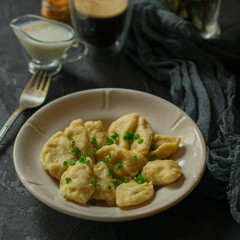 Dumplings in white plate (dough with different fillings). food background. dark background. top