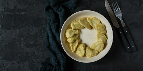 Dumplings in white plate (dough with different fillings). food background. dark background. top