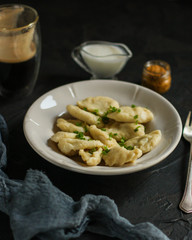 Dumplings in white plate (dough with different fillings). food background. dark background. top
