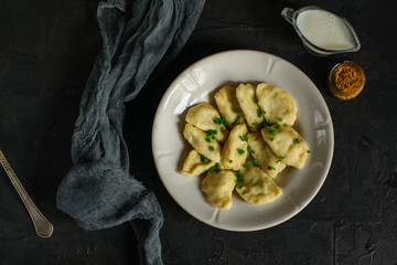Dumplings in white plate (dough with different fillings). food background. dark background. top
