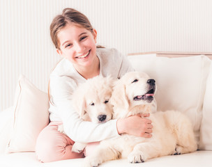 Smiling girl hugging puppies