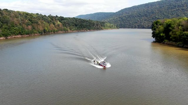 Motor boat speeding on lake surface, water splashing off the bow, Raystown lake in Pennsylvania offers many outdoor recreational activities on water, watersports and travel concept