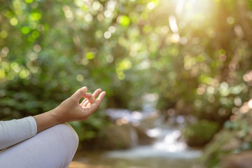 Beautiful girls are playing yoga at the park. Among the natural waterfalls in the forest, exercise concepts