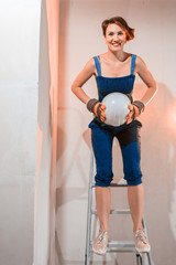 Sexy girl who is builder, painter, worker being in a renovated room