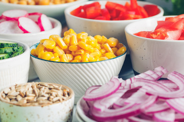 Assortment ingredients for healthy vegetarian salad in different portion bowls on a table. The concept of fitness and vegan food.