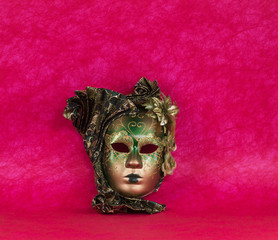 green Venetian masquerade mask on a red background