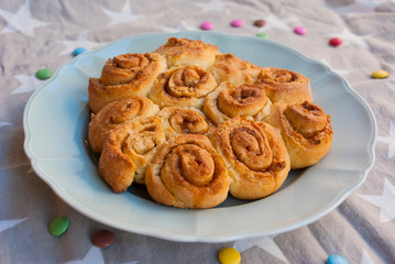 Homemade cinnamon roll pie on holiday towel with stars.