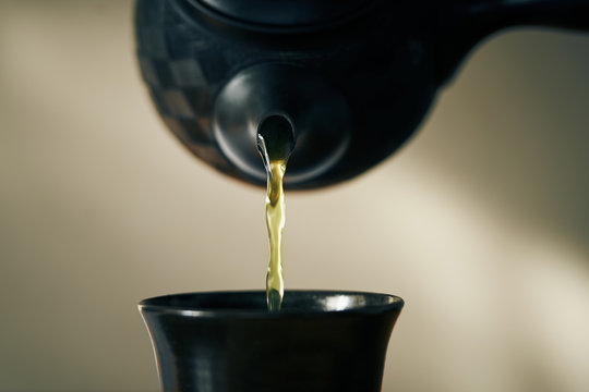 Close up of tea pouring into cup from teapot