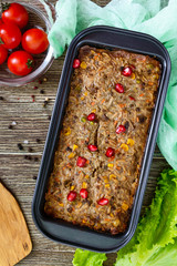 Liver casserole. Useful dish from the liver. Freshly baked pork liver souffle with rice and vegetables on a wooden table. Top view.
