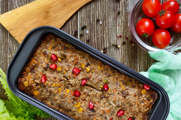 Liver casserole. Useful dish from the liver. Freshly baked pork liver souffle with rice and vegetables on a wooden table. Top view.