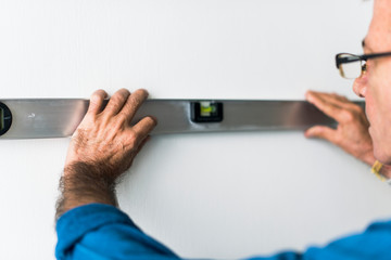 Man using a spirit level on a wall
