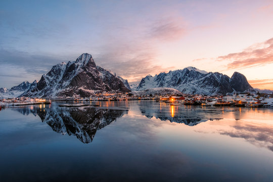 Fishing village with snow mountain at sunrise
