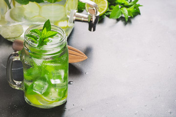 Mojito cocktail in mason jar on black stone table. Copy space for text.