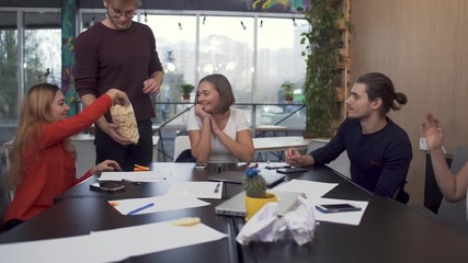 Friendly team is very happy to solve the problem and funny cheerful member throws popcorn at the colleagues