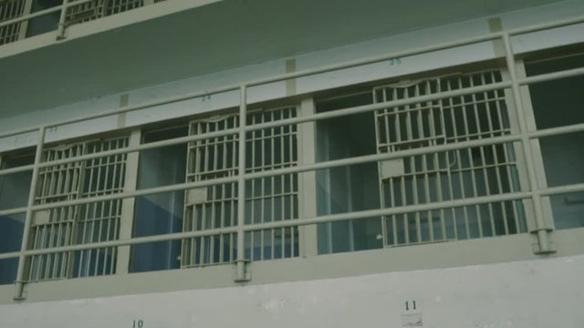 Tilt up from open cell doors to empty prison cells on Alcatraz island