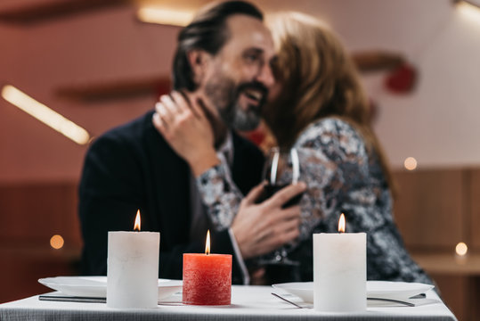 Man and woman in a restaurant are hugging at a table Soft focus