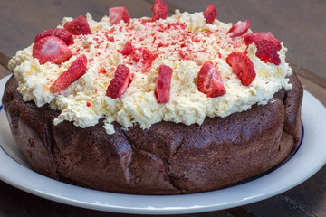 chocolate cake topped with freeze dried strawberries and cream
