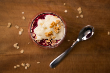 looking down on glass of stewed plums with oats and custard