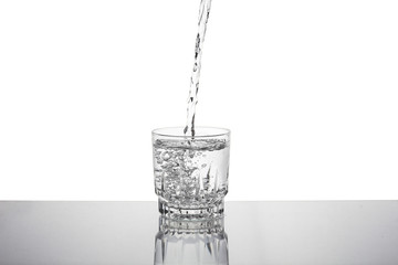 Water falling in glass on isolate background.