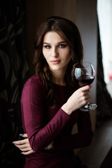 Beautiful young woman with red wine.beauty girl with wineglass. she enjoys the scent of wine