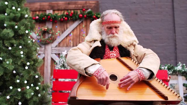 Sliding portrait of white bearded old man playing dulcimer and singing