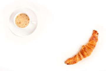 An overhead photo of a cup of coffee with a croissant, shot from above on a white background, forming a frame for copy space