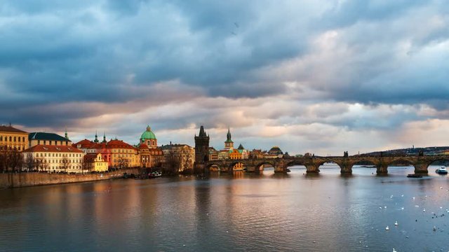 Prague, Czech Republic. Charles Bridge over Vltava river in Prague, Czech Republic. Timelapse during the sunset with touristic boats and Old Town Bridge Tower. Cloudy, day to night timelapse, zoom in