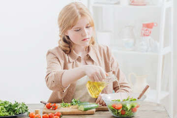 teen girl prepares salad at home