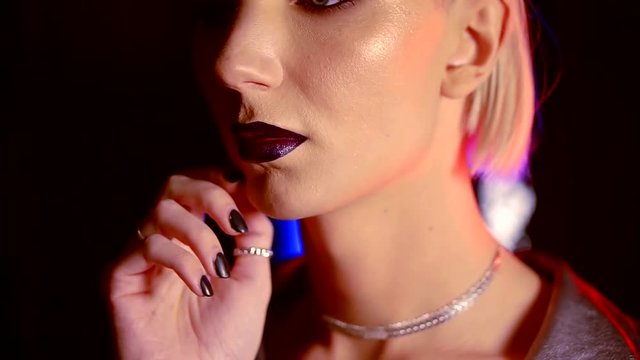 androgyny male model is looking like a woman is touching face by manicured hand, close-up