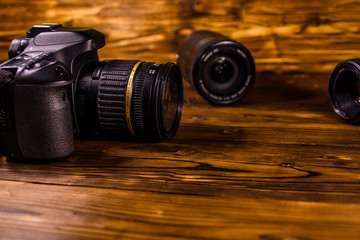Fototapeta na wymiar Modern dslr camera and lenses on wooden table