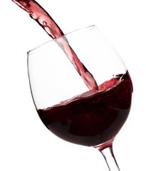 Beautiful splash of red wine in a glass on white background.