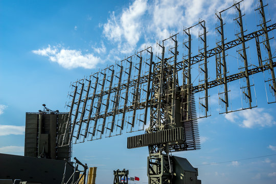 Air Defense Radars Of Military Mobile Antiaircraft Systems, Modern Army Industry On Background Beautiful Clouds And Blue Sky