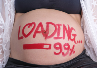pregnant woman with loading 99% concept painted on belly